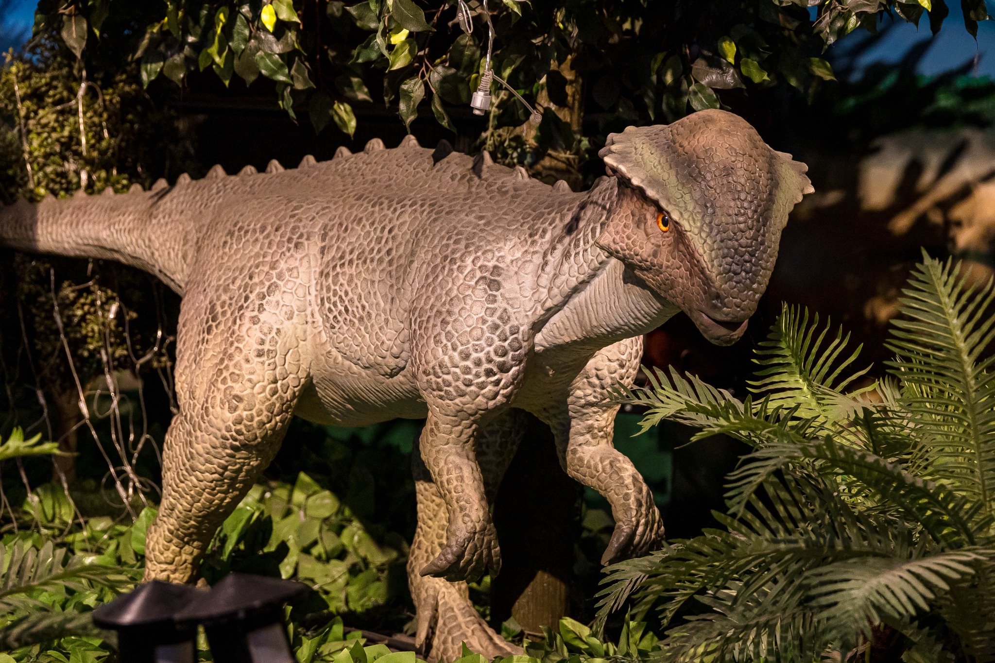 A dinosaur model looking out from the restaurant's prehistoric scenery.
