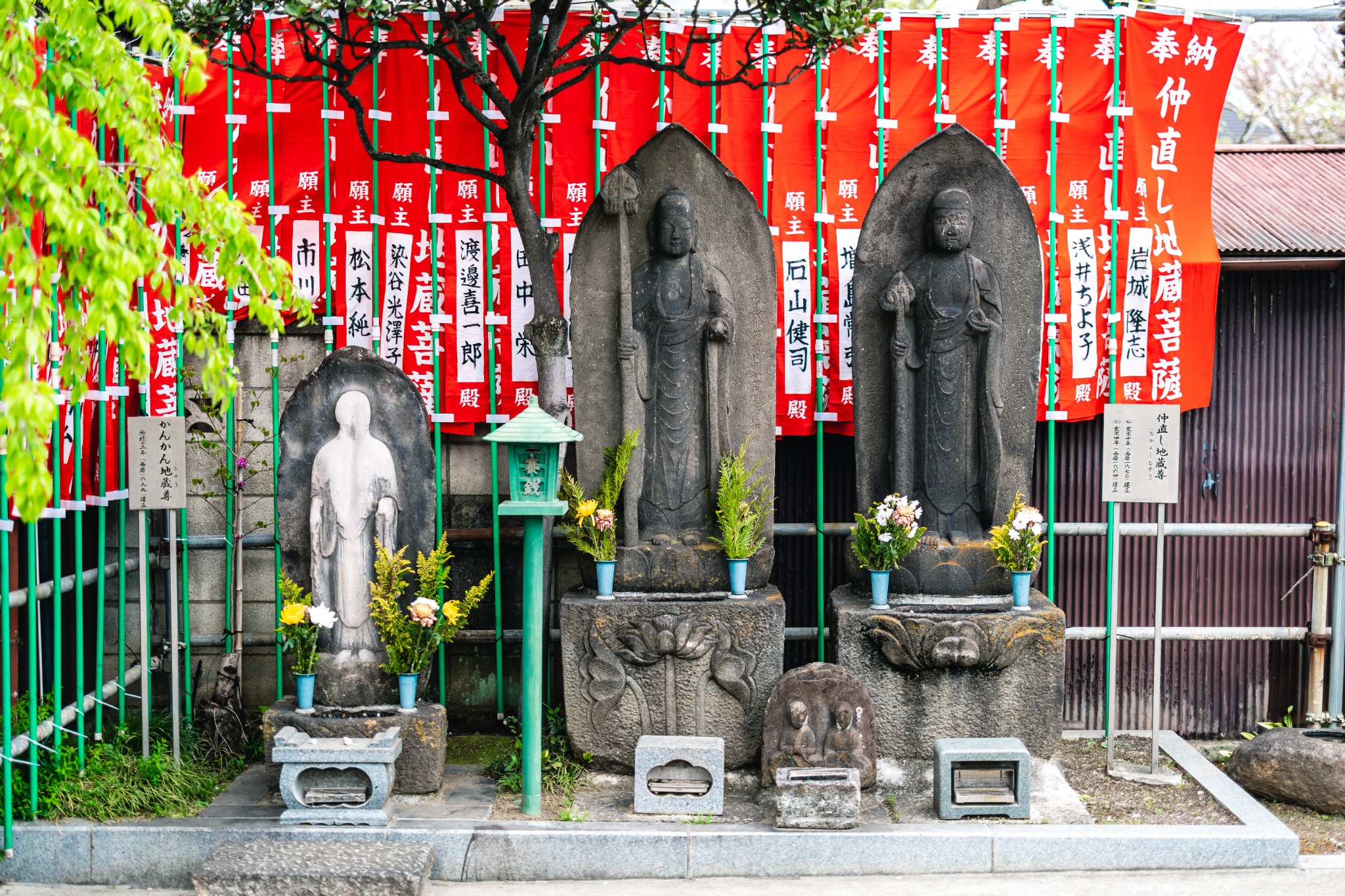 Kankan Jizō standing beside less-worn neighbouring stone figures at Anyoin Temple.