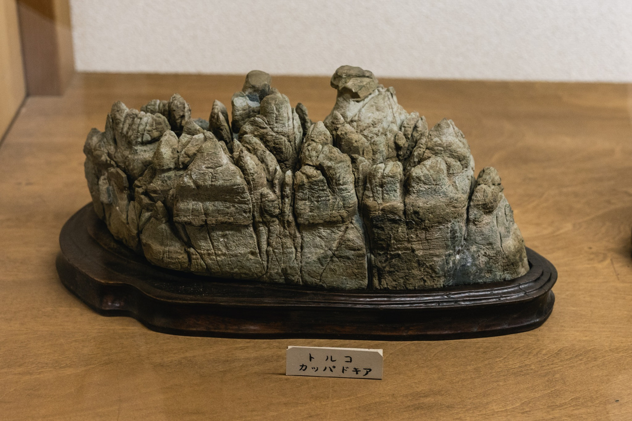 A stone resembling a cluster of towers and rocky pinnacles on a fitted wooden base.