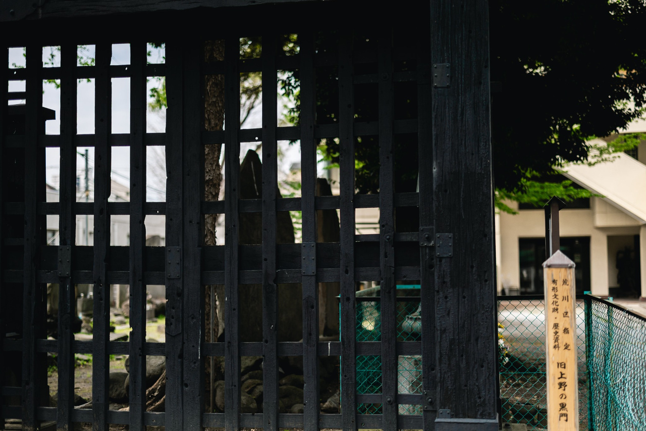Bullet scars from the 1868 Battle of Ueno visible in the dark wooden timbers of the Kuro-mon.