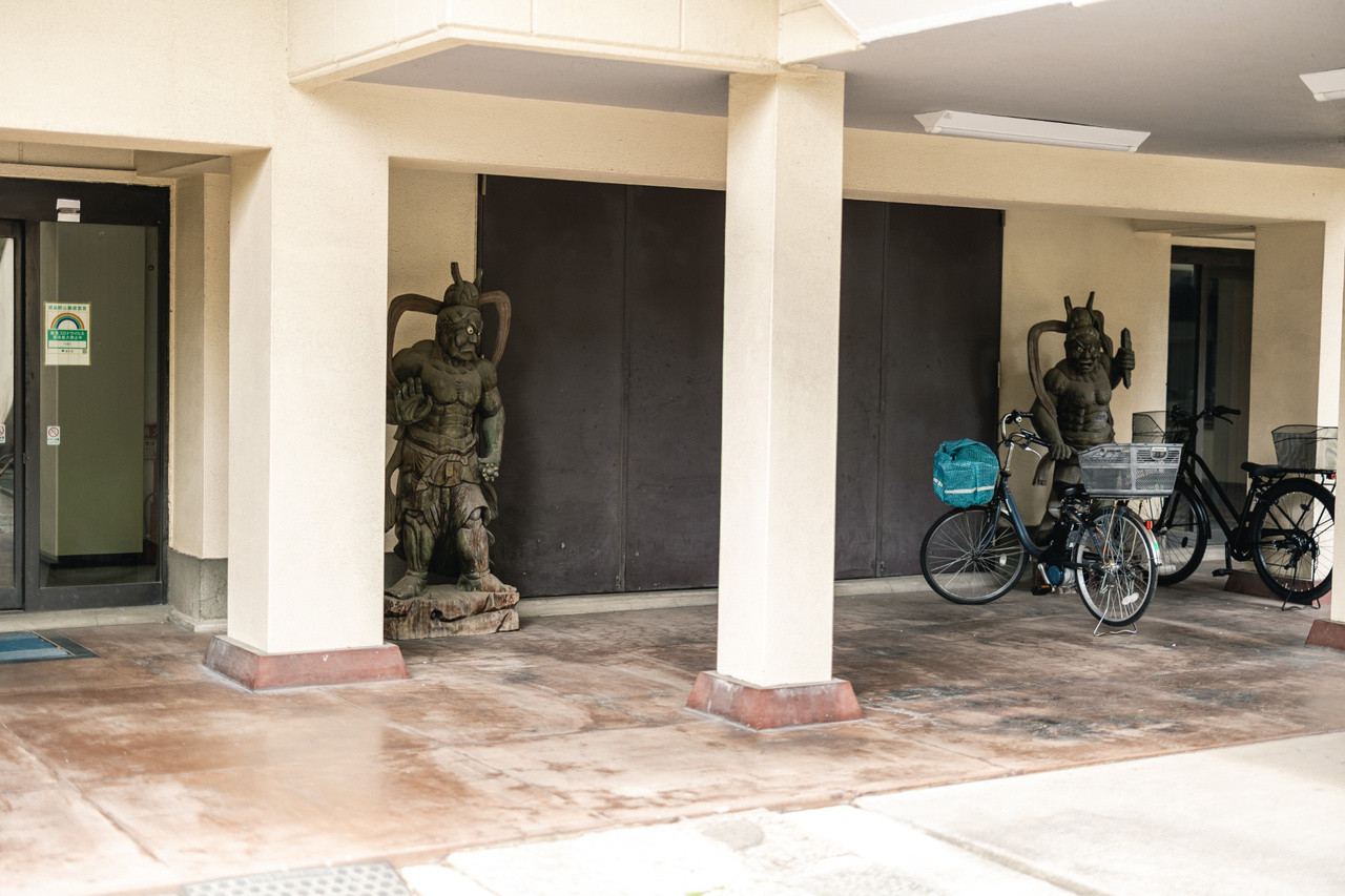 Niō guardian statues beside the entrance to Entsuji Temple, with bicycles parked nearby.
