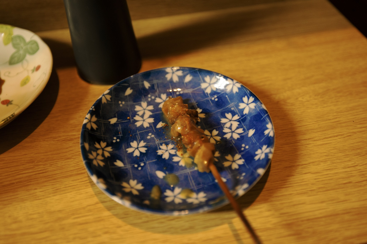 A skewer of doteyaki, tender beef tendon coated in a sweet white-miso-based sauce, at Kikuya.