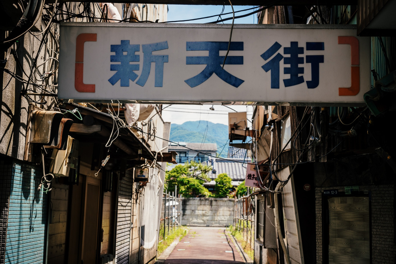 Northern end of the surviving Kofu Shintengai alley where the built-up passage begins to open into vacant land.