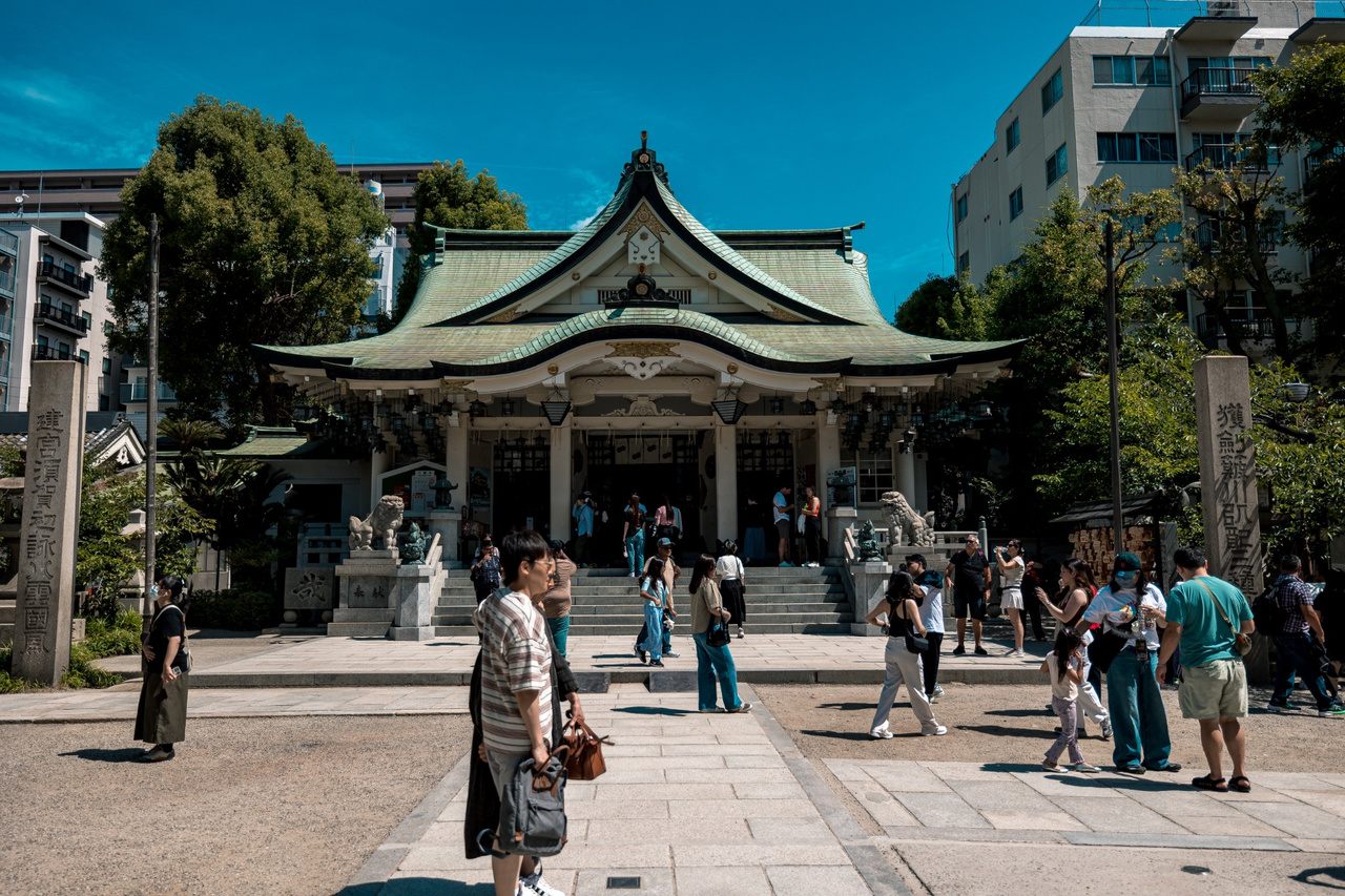 Main sanctuary building at Namba Yasaka Shrine, decorated with shimenawa and lanterns.