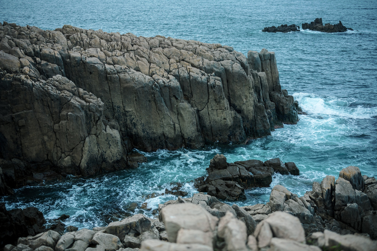 Exposed rock ledge at Tojinbo dropping directly toward the Sea of Japan below.