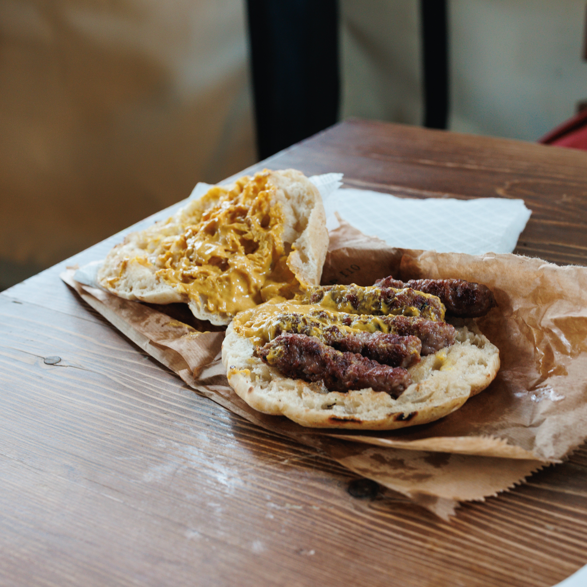 Ćevapi in opened bread with mustard at Ćirino Drvce in Belgrade.