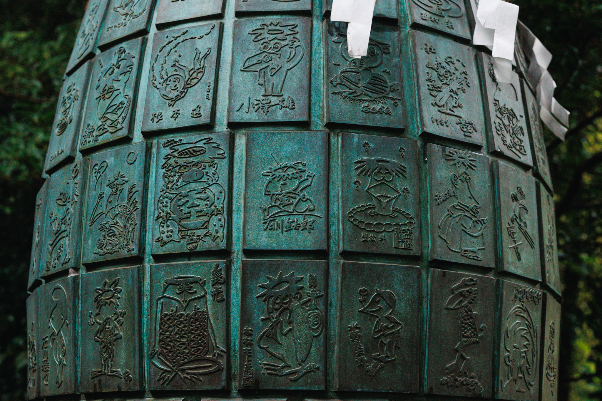 Bronze relief panels on the Efudezuka at Egara Tenjin Shrine, each showing a kappa drawn by a different cartoonist