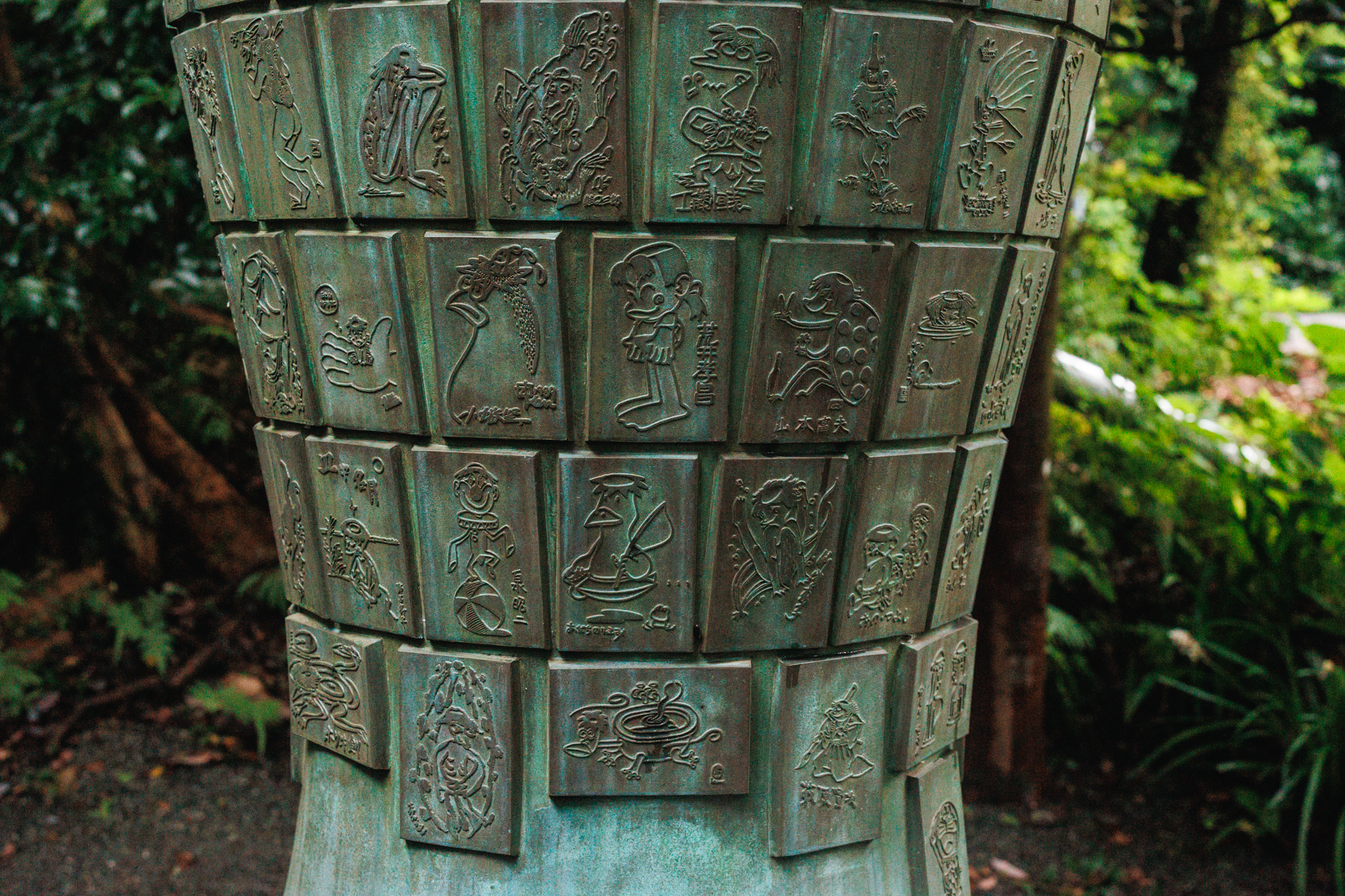 Lower rows of kappa relief panels curving around the bronze base of the Efudezuka