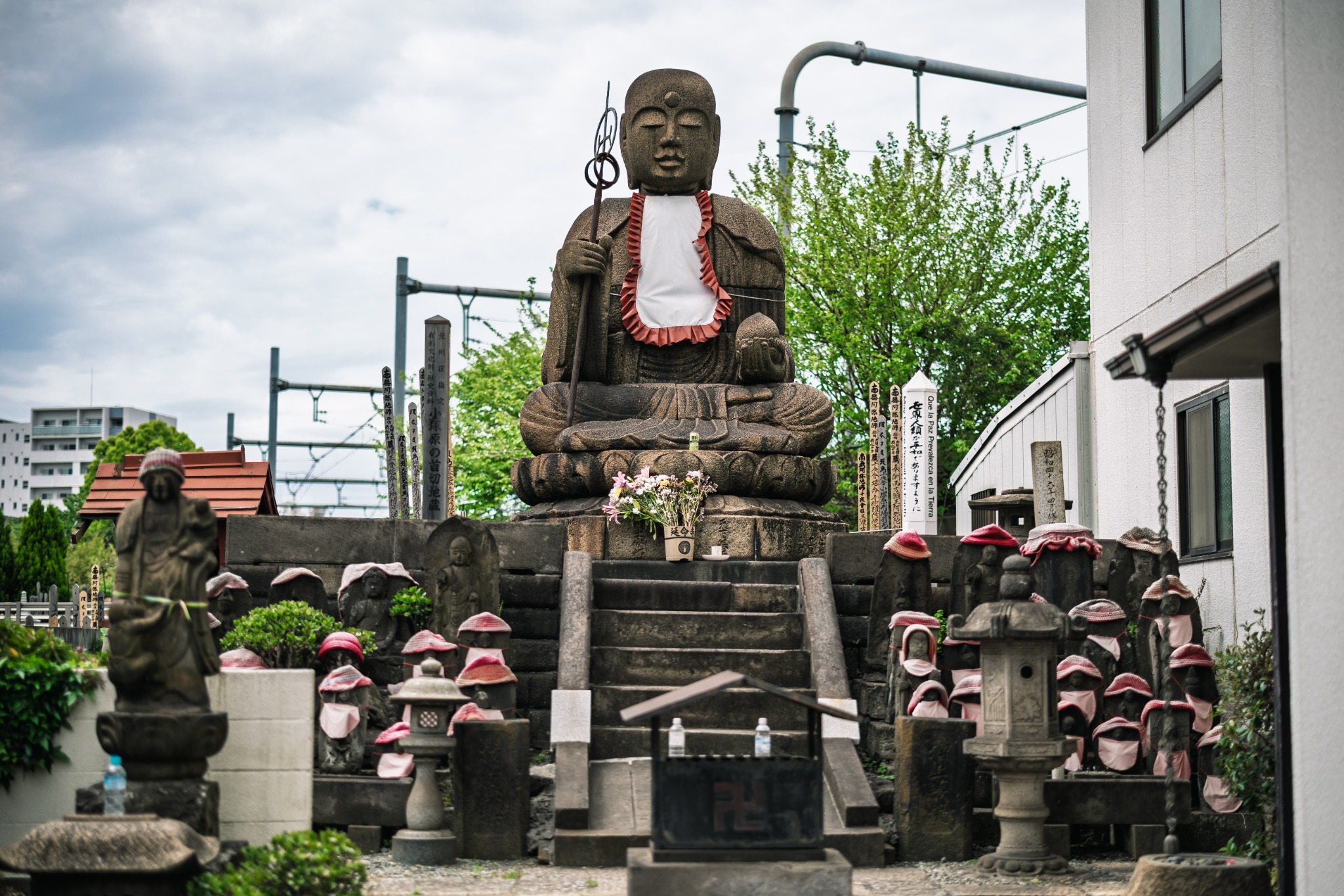Nearly four-metre stone Kubikiri Jizō at Enmeiji Temple, surrounded by smaller Jizō and memorial stones in Tokyo.