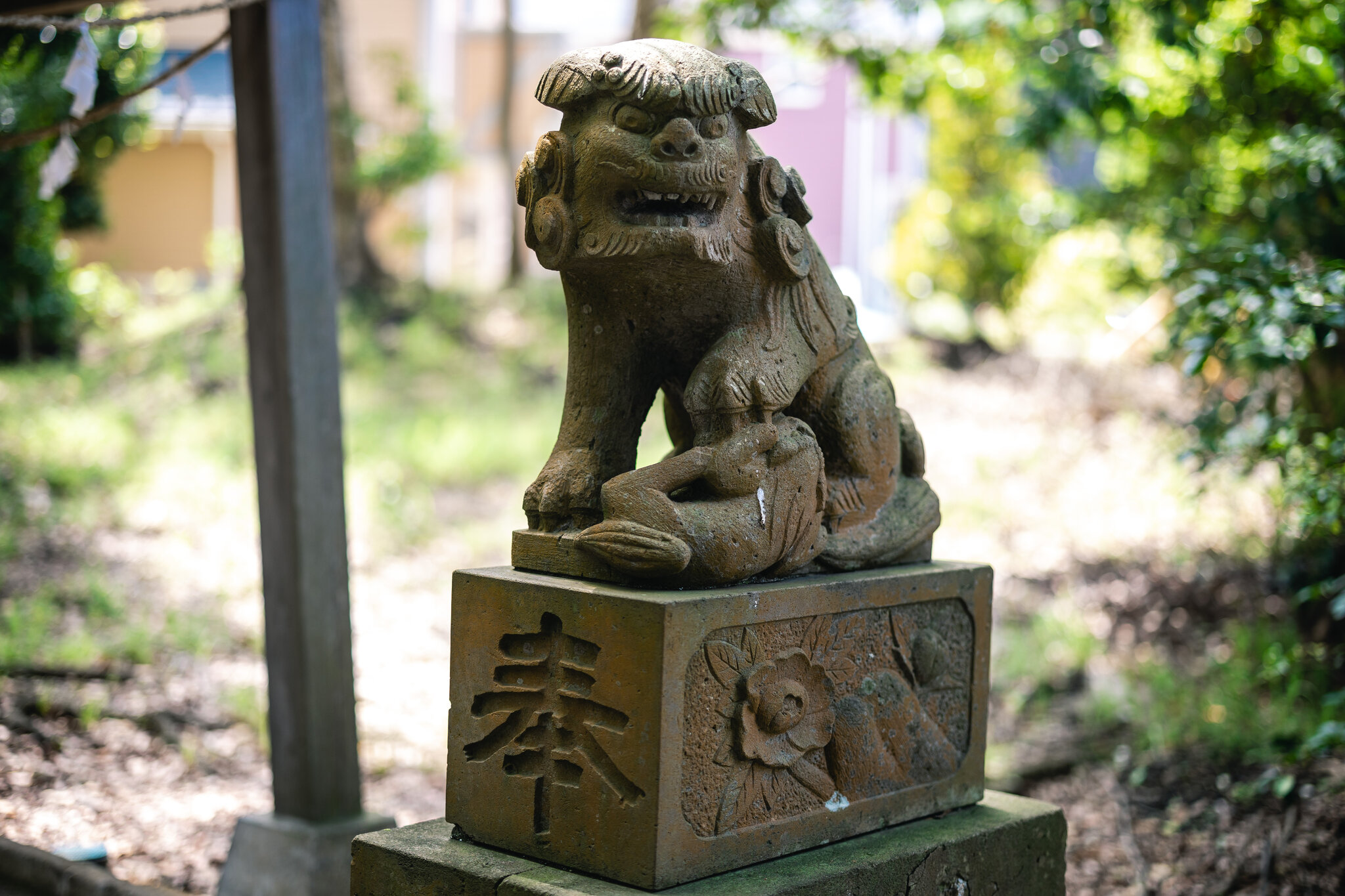 A stone guardian with a much smaller lion twisting beneath its front paw at Goryō Shrine.