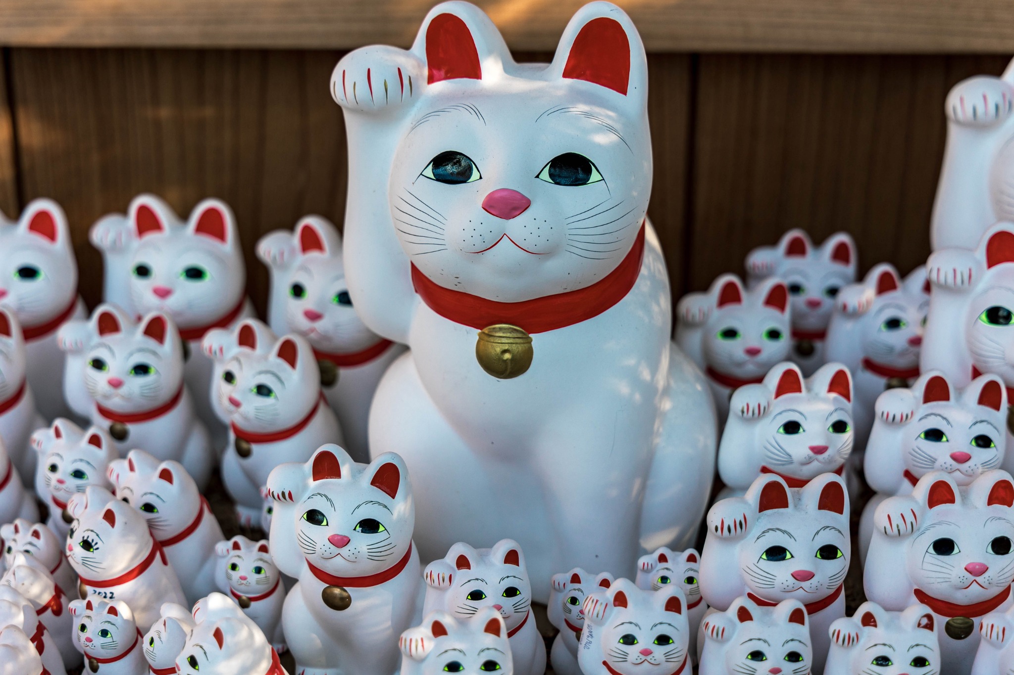 Large and small Gotokuji maneki-neko figures raising their right paws without holding koban coins.