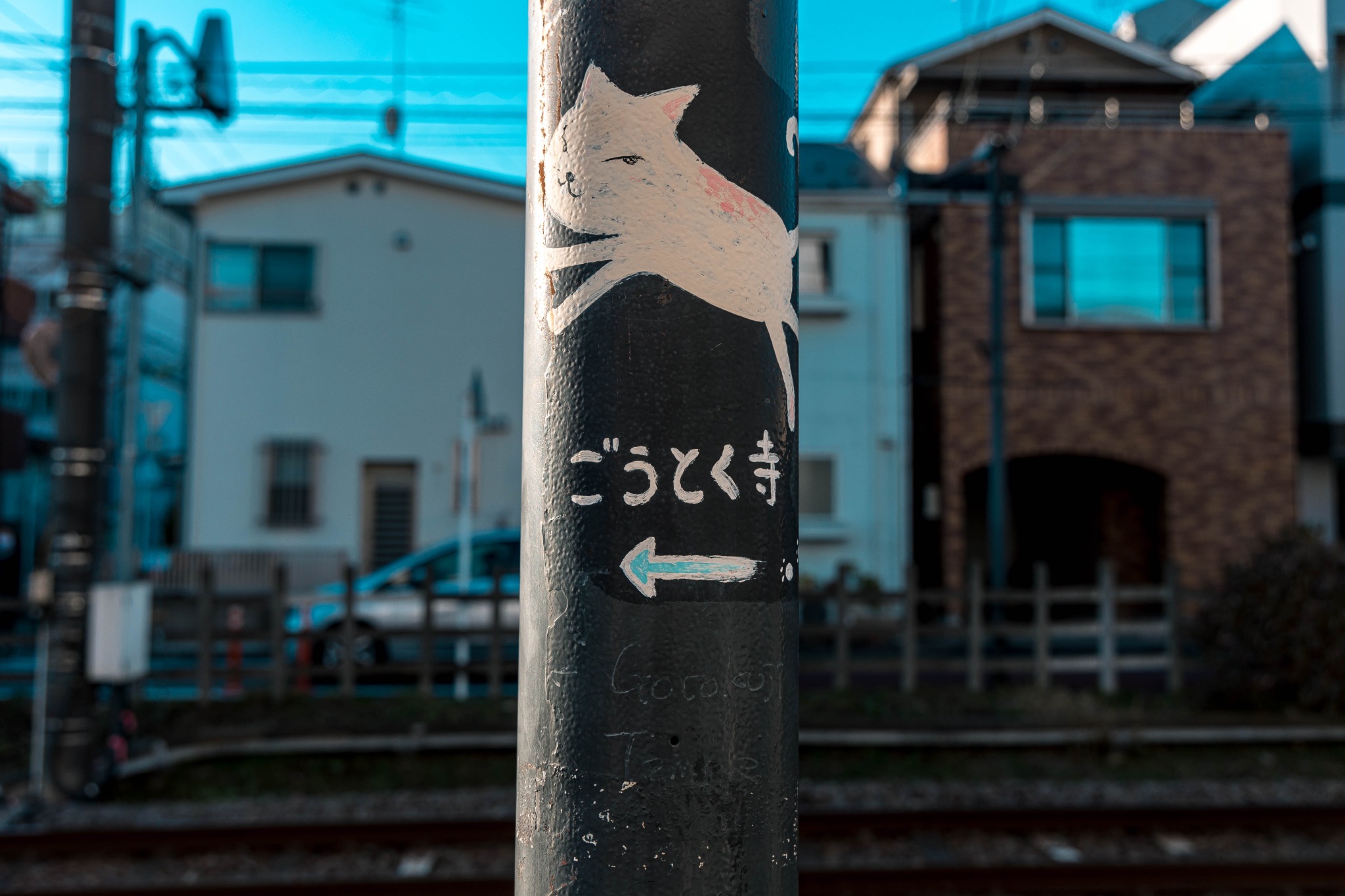 Cat-themed direction sign pointing visitors toward Gotokuji Temple in Setagaya.