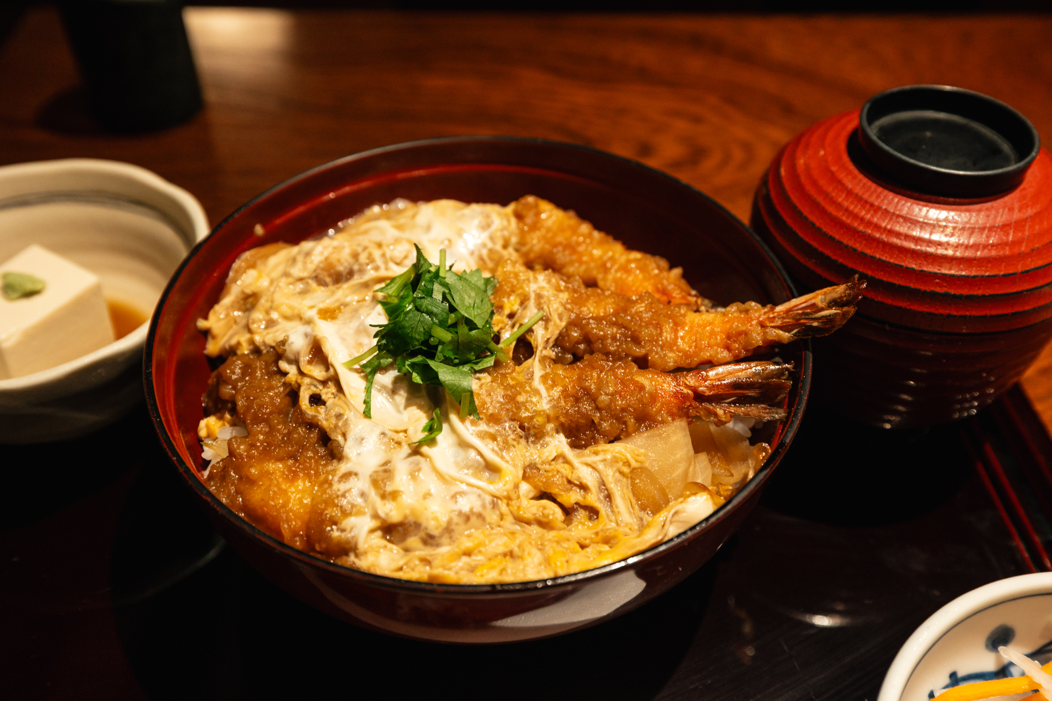 Two large prawn tempura pieces covered with egg and onion over rice at Minemoto in Kamakura.