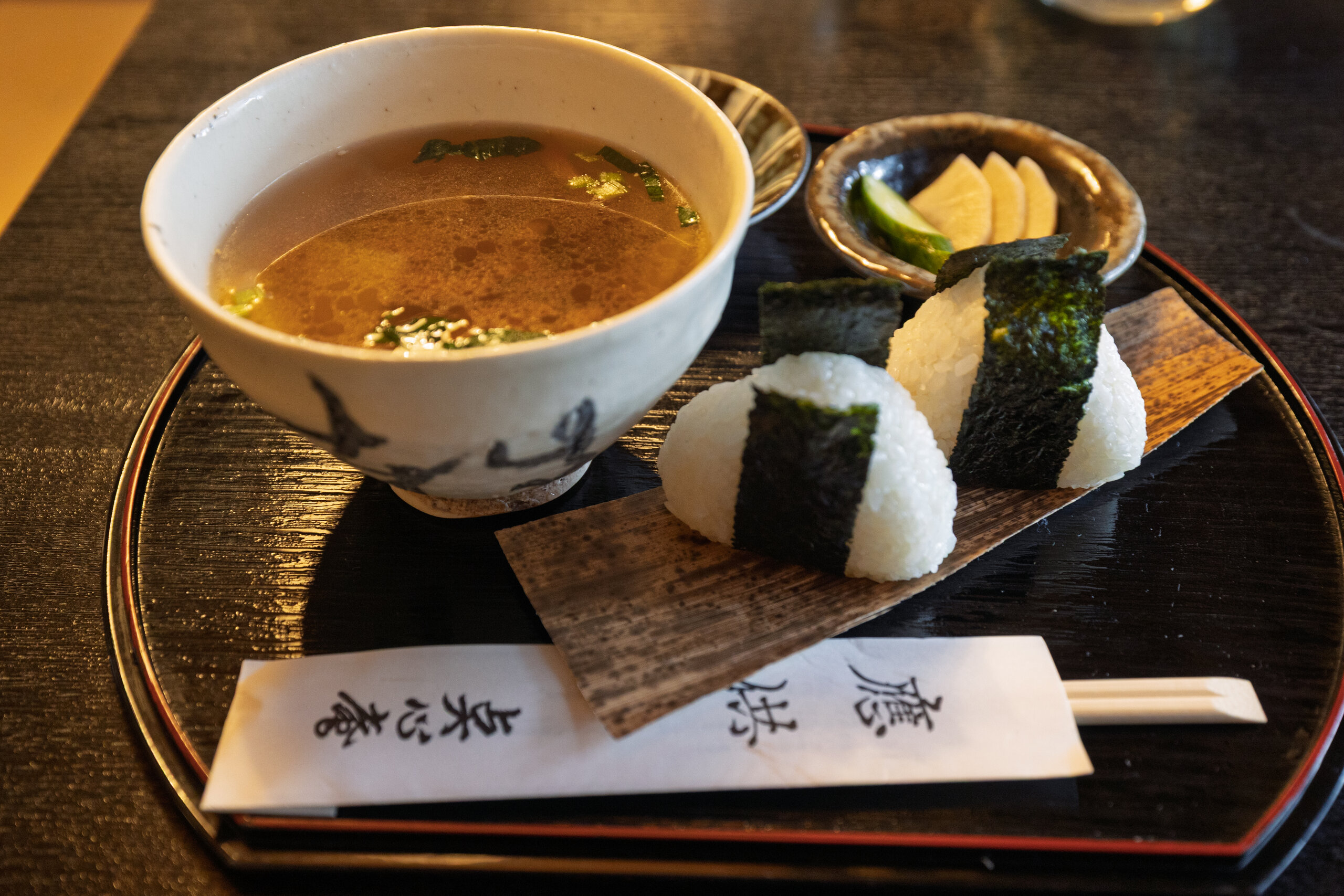 Kenchinjiru set at Tenshin-an in Kita-Kamakura, with an amber bowl of vegetable soup and two nori-wrapped rice balls.