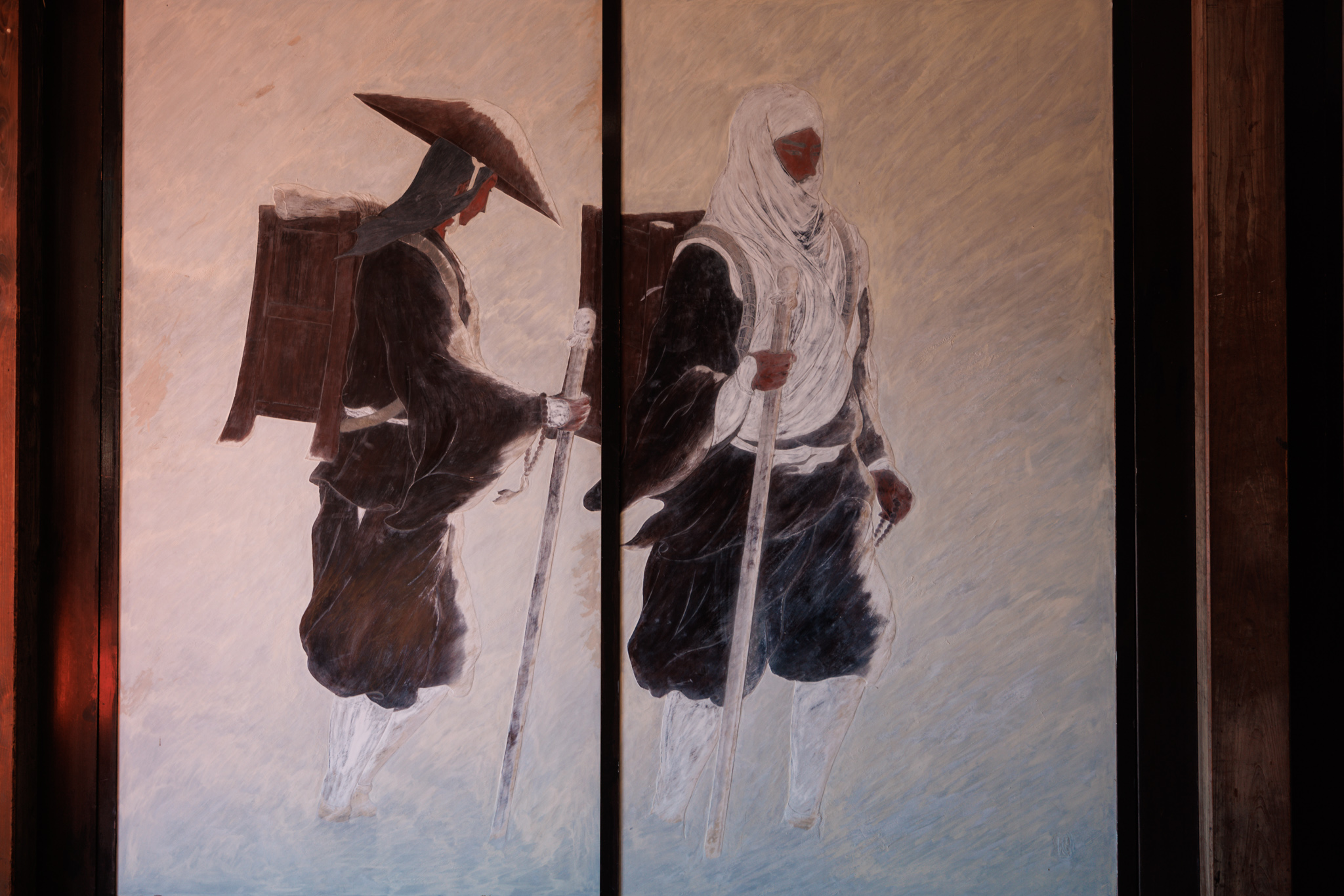 Two sliding doors painted with two travellers walking through slanting strokes, one in a wide hat with a wooden pack on his back, the other in a white hood, both carrying staffs