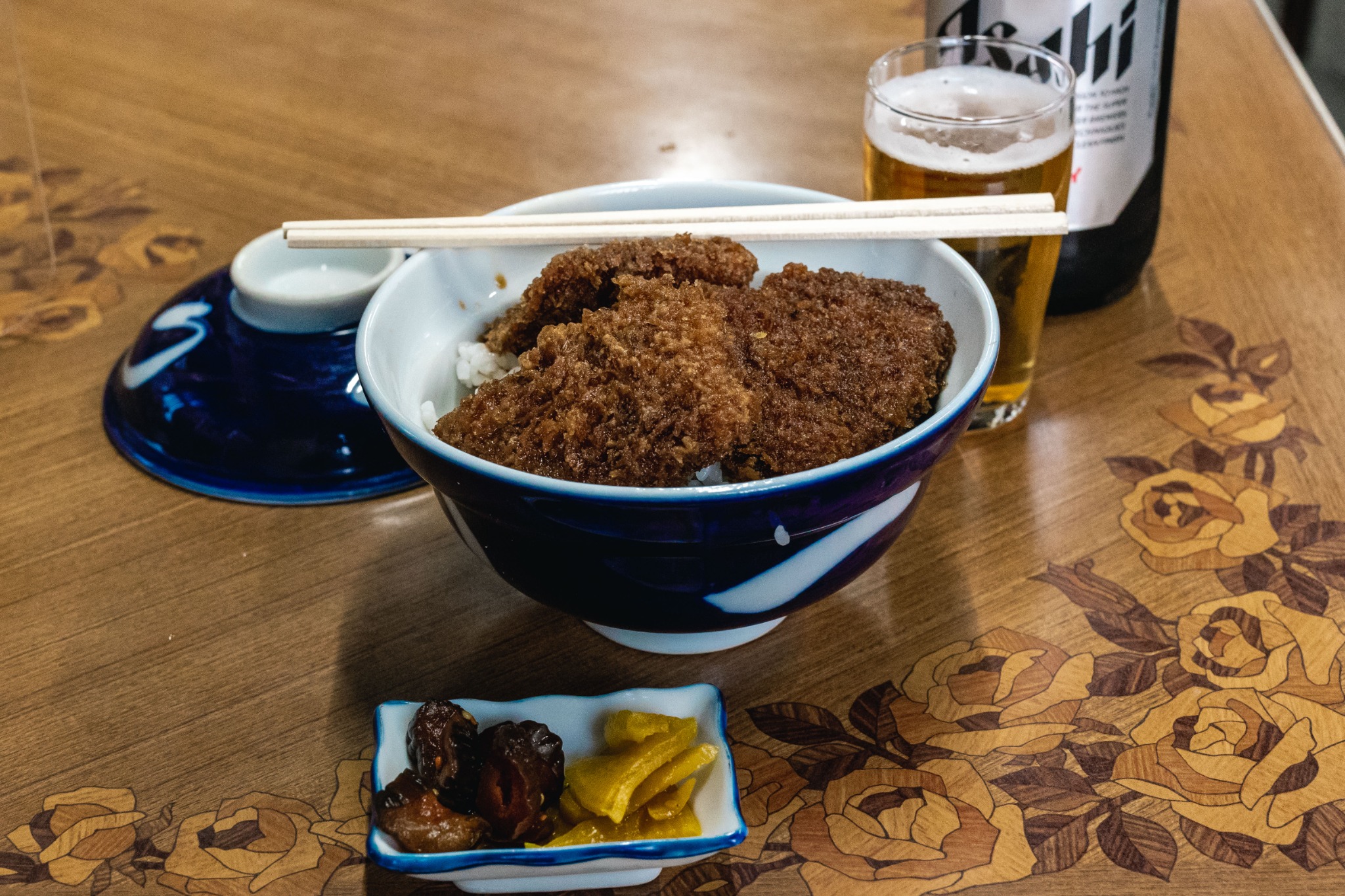 Sauce katsudon at Pari Shokudo, with sauce-coated pork cutlets covering most of the rice in a lidded bowl.
