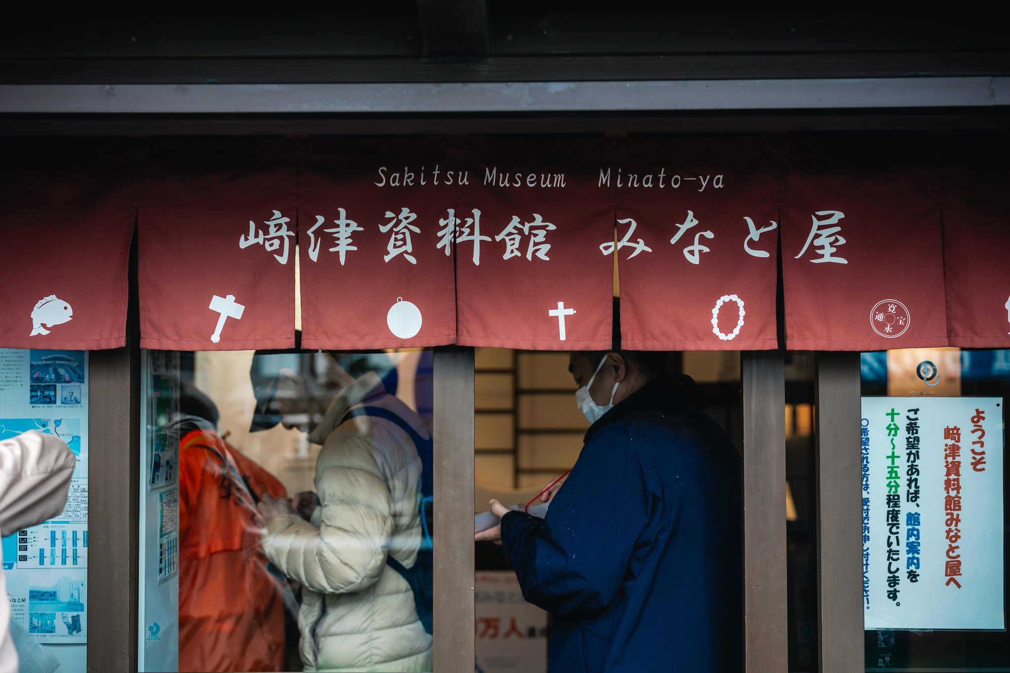 The red curtain of Sakitsu Museum Minato-ya, printed with a fish, a mallet, a round mirror, a cross, a rosary and an old coin
