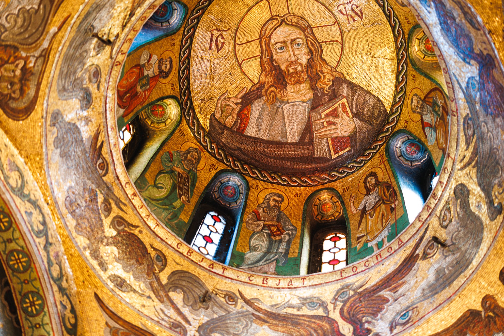Christ depicted amid golden mosaic patterns inside the dome of St. Petka Chapel in Belgrade.