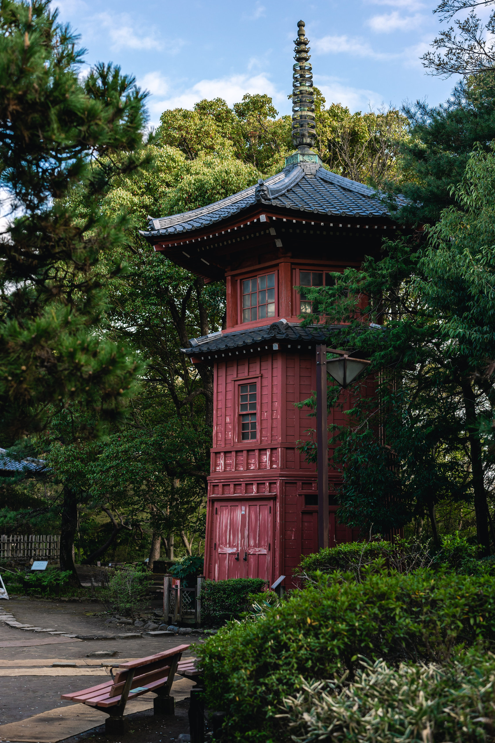 The red Rokkendai tower rising among trees at Tetsugakudo Park.