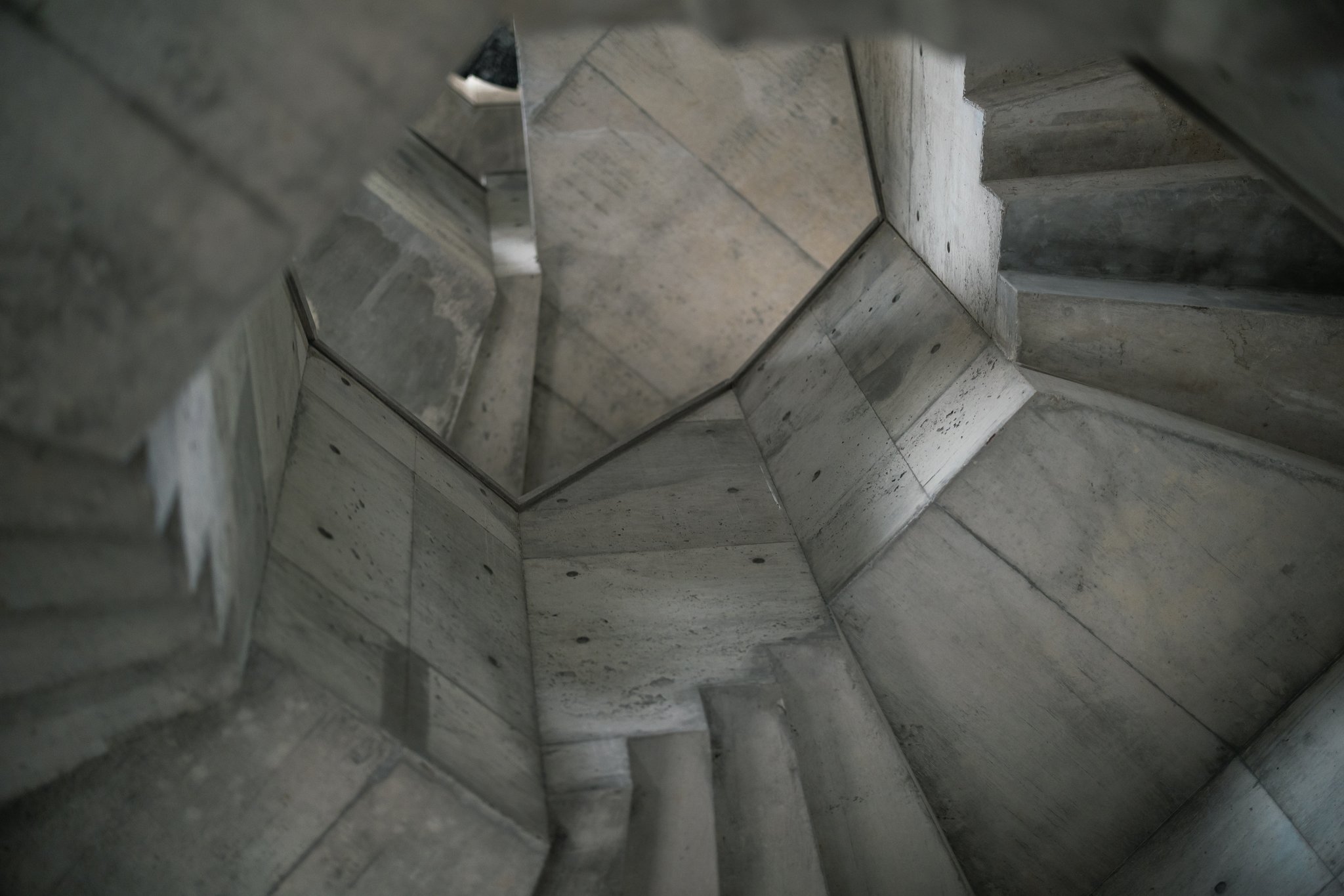 An octagonal concrete stairwell inside the observation tower, with steps winding around the walls