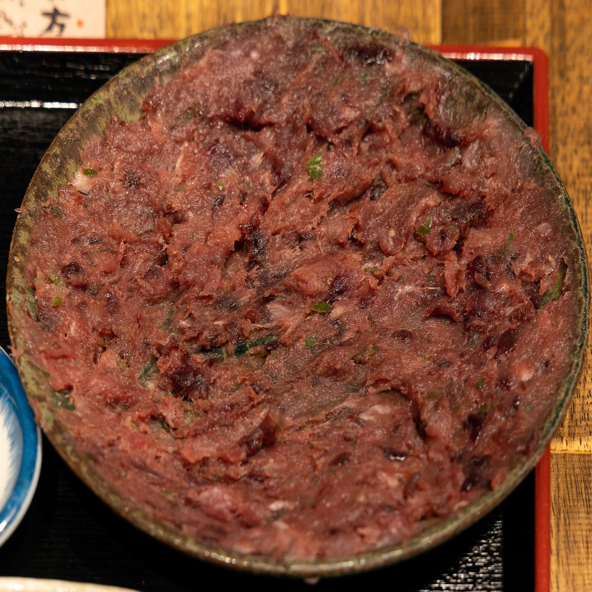 Finely chopped dark-red uzuwa spread almost edge to edge across a ceramic plate.